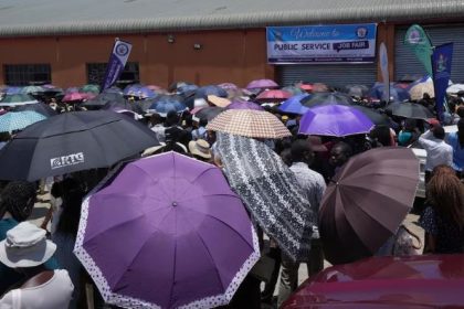 Young people wait outside the entrance to a government job fair, in Harare, Wednesday, Dec. 6, 2023